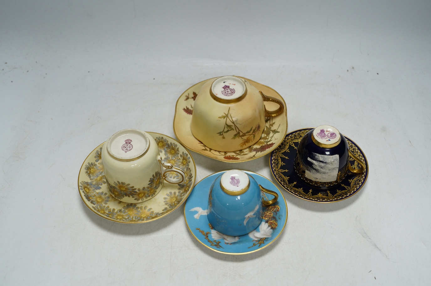 Four miniature Worcester cups and saucers, including a blush ivory ground, one signed G Johnson, largest 12.5cm wide. Condition - fair